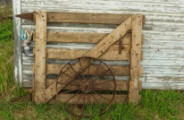 This frame shows a gate for a box stall and an old wagon wheel.